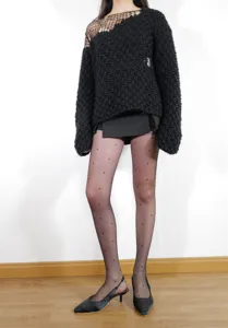 Close-up detail of black dotted sheer pantyhose, natural bare-leg look with knit outfit.