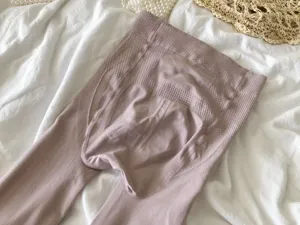 Detail shot of Morandi pink shaping tights with peach hip lift and tummy control, fine-ribbed.
