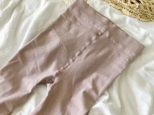 Closeup detail of women's high-waist shaping knitted leggings in soft nude tone.