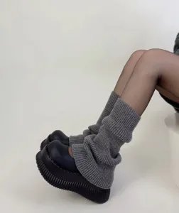 Primo piano di scaldamuscoli in maglia grigia con tessuto lavorato e design confortevole.