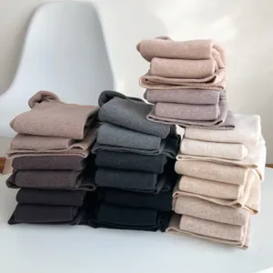 Detailed view of folded fleece-lined thermal leggings in various neutral colors, soft texture.