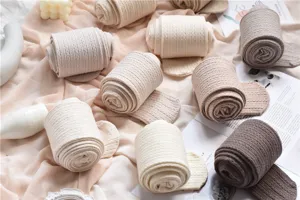 Detalle de medias de punto de color crema acogedoras, leggings cálidos de invierno en tonos neutros.