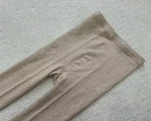 Close-up view of women's knit winter warm tights showing fine textured wave patterns clearly.