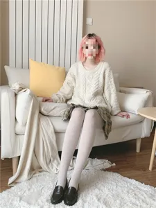 Close-up detail of cozy ribbed knit tights paired with casual sweater and plaid skirt.