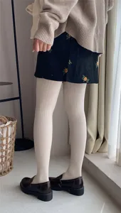 Vista detallada otoño invierno mujer medias de canalé crema, leggings gruesos color avena.