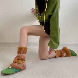Detail shot of gradient knitted leg warmers showing warm winter texture and stylish color block.