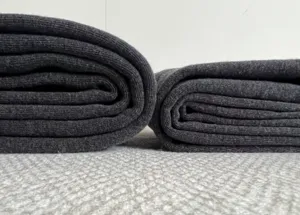 Detail shot of dark grey fleece-lined thermal leggings with ribbed knit texture.