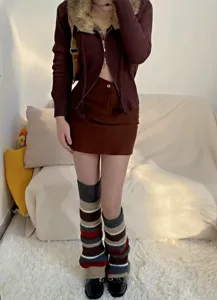 Detailaufnahme von modisch gestreiften Strick-Beinwärmern zum Herbstoutfit im gemütlichen Raum.