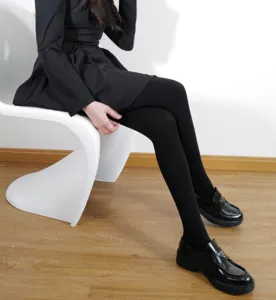 Detail shot of women wearing warm fleece-lined black tights paired with stylish loafers.