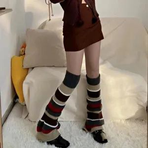 Detailansicht der gestrickten Beinwärmer mit buntem Streifenmuster und weitem Beinschnitt.