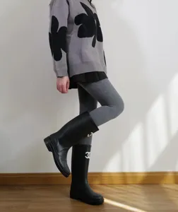 Vista dettagliata di leggings grigi a costine a vita alta abbinati a stivali eleganti.