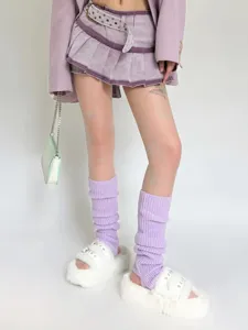 Close-up detail of soft purple knit leg warmers, styled with fuzzy white slippers and skirt.