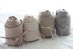 Vue détaillée de collants en coton côtelé couleur avoine, joliment enroulés avec des rubans.