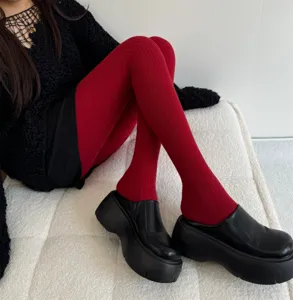Close-up of women's warm red ribbed tights, stretch knit fabric for autumn and winter daily wear.