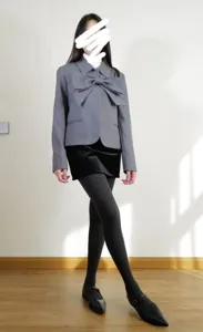 Vista dettagliata di collant termici a vita alta abbinati a un elegante blazer grigio.