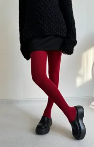 Detail shot of warm red ribbed pantyhose featuring high elasticity and soft knit texture.