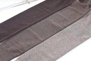 Detalle de medias de algodón gruesas con forro polar en tonos cálidos caramelo y marrón.