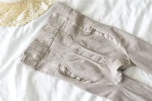 Vue détaillée de collants en tricot côtelé, avec tissage sculptant et texture douce en coton.