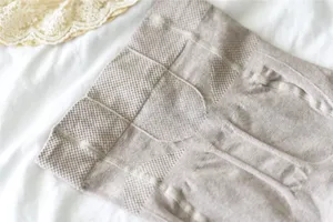 Détail de collants en coton côtelé couleur avoine, taille haute, tricot amincissant.