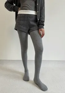 Detail view of thick grey dot jacquard pantyhose, cozy autumn winter hosiery for women.