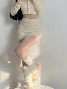 Cozy winter knitted leg warmers and fuzzy outfit detail showing soft texture and warm style.