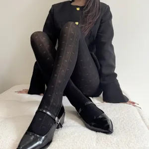 Black jacquard tights with vintage heart and bow pattern, seamless toe, cozy autumn winter hosiery.