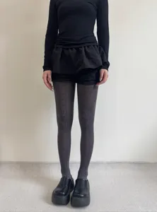 Detail shot of vintage dark pattern jacquard tights paired with black platform shoes.