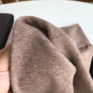 Close-up of thick thermal knit fabric texture, soft brown fleece lining material detail.
