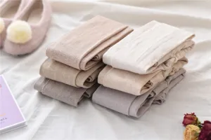 Detail shot of winter vertical striped cotton leggings in soft oatmeal and grey neutral tones.