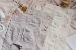 Primer plano de medias de canalé color crema gruesas, mostrando detalles de punto suave.