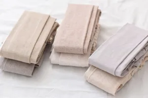 Close-up detail of folded ribbed knit autumn winter leggings in soft neutral oatmeal and beige.