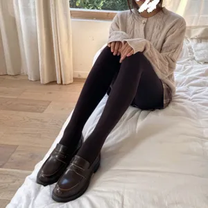 Detailed view of thick thermal fleece-lined tights worn comfortably in a cozy bedroom setup.