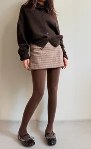 Close-up view of dark chocolate brown thermal tights styled with cozy outfit details.