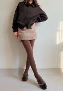 Detailed view of brown tights, soft opaque fabric showcasing an elegant and slim fit styling.