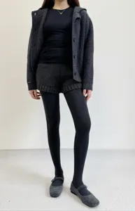 Detailed view of dark grey knitted leggings and cardigan outfit, soft fabric, warm and stylish.