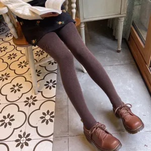 Detailed view of women's warm fleece-lined brown leggings paired with retro leather shoes.