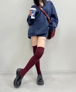 Detailed view of burgundy over-the-knee slouchy socks styled with platform shoes.
