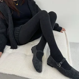 Dark grey winter thermal opaque pantyhose tights paired with cozy knit shoes for women.