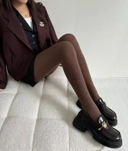 Detailed view of women's warm knit tights in dark brown with water ripple texture.