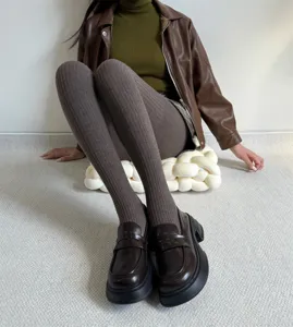 Close-up detail shot of winter ribbed tights and loafers, cozy knit texture, warm style.