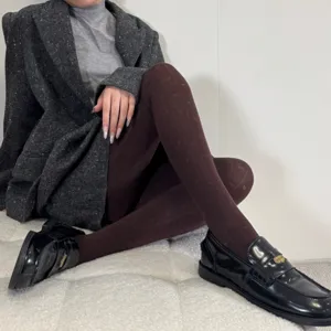 Detail shot of women winter jacquard tights paired with black loafers and grey outfit.