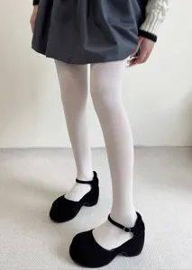 Close-up detail of white jacquard tights with cute bow patterns, cozy and stylish daily wear.