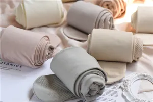 Detailed shot of rolled winter fleece lined tights in neutral cream, grey and nude tones.