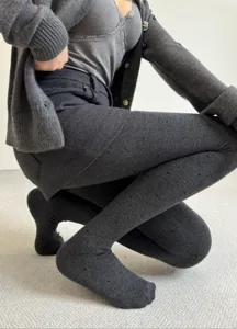 Detail view of grey fleece-lined polka dot tights, warm and stretchy winter wear.