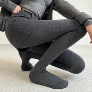 Close-up view of grey thick fleece-lined polka dot tights with skirt design, showing fabric texture.