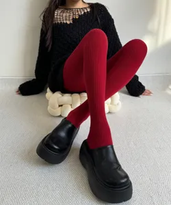 Close-up detail of women's red ribbed thermal tights paired with black platform shoes.