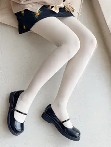 Close-up detail of women cream pantyhose, comfortable nylon tights worn with black shoes.