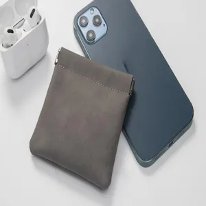 Grey leather spring storage bag for earphones and small cables, compact portable pouch.