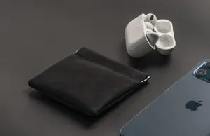 Close-up detail of a portable black leather squeeze pouch for cables and small accessories.