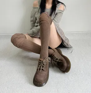 Detailed shot of brown ribbed knit over-the-knee socks paired with stylish platform shoes.